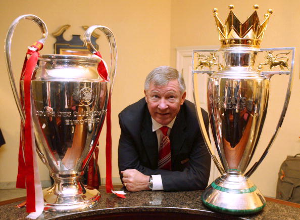 Sir Alex Ferguson of Manchester United poses with the UEFA Champions League trophy and the FA Barclays Premier League trophy 2008