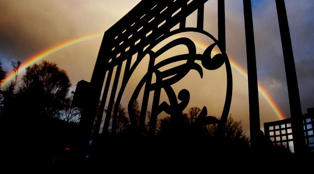 A rainbow forms behind the silhouetted gates of Murray Park, Rangers’ training ground