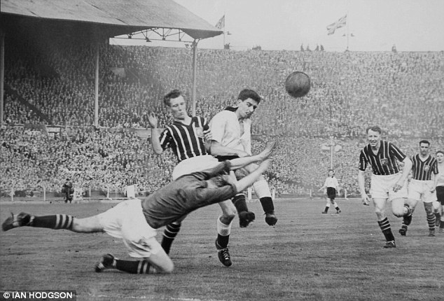 Brown challenges Manchester City keeper Bert Trautmann during the 1956 FA Cup final