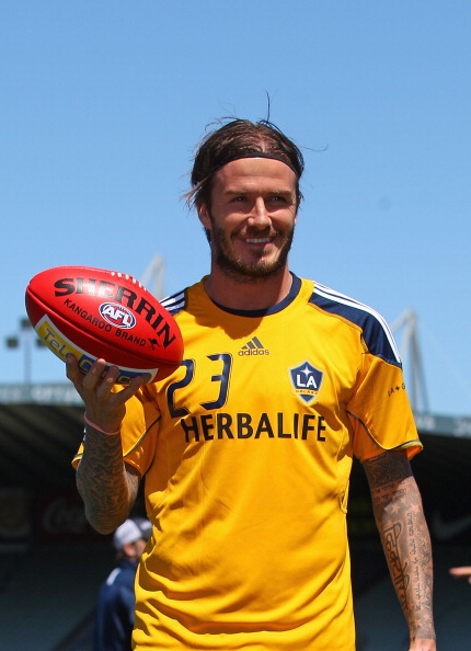 David Beckham of the Galaxy poses with an Australian Rules AFL football during an LA Galaxy training session at Visy Park on December 5, 2011 in Melbourne, Australia