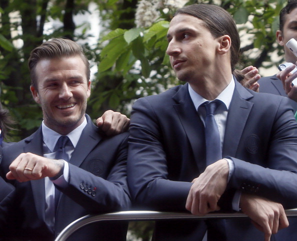 Paris Saint-Germain's David Beckham (L) parades with teammate Zlatan Ibrahimovic on a double decker bus May 13, 2013 Paris, one day after Paris French L1 football championship title