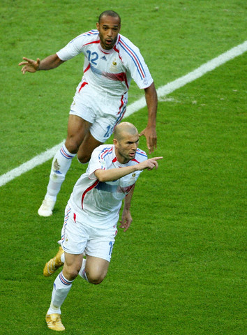 French team captain Zinedine Zidane (front) celebrates with his team-mate Thierry Henry after scoring the penalty shot during the FIFA World Cup 2006 final between Italy and France.