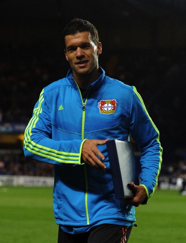 Michael Ballack of Bayer Leverkusen leaves the field with an award received from Chelsea chairman Bruce Buck prior to kick-off 2011